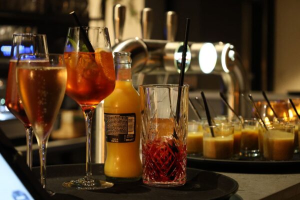 An artistic display of cocktails and juice glasses at a stylish bar.
